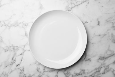 Stylish ceramic plate on marble background, top view