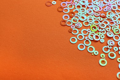 Shiny bright glitter on orange background. Space for text