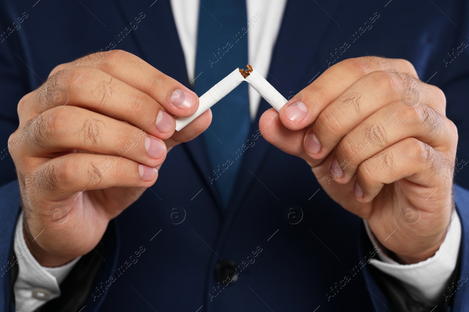 Photo of Stop smoking concept. Closeup view of man breaking cigarette