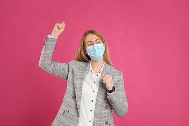 Emotional businesswoman with protective mask on pink background. Strong immunity concept