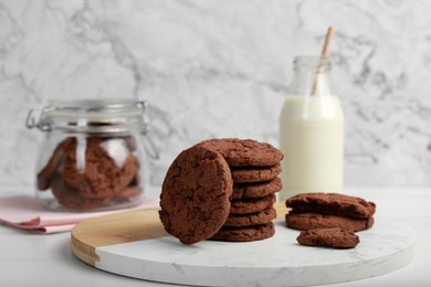 Board with tasty chocolate cookies on white table