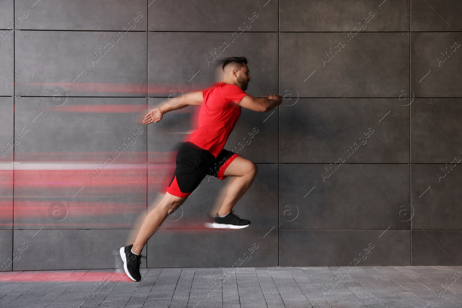 Image of Sporty young man running on street. Light trails showing his speed