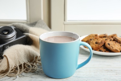 Photo of Cup of hot cocoa on window sill. Winter drink