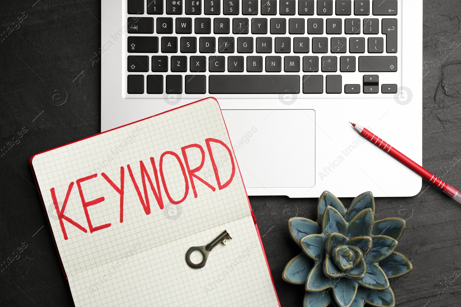 Photo of Notebook with word KEYWORD, laptop and key on black table, flat lay