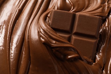 Photo of Tasty milk chocolate paste and pieces as background, closeup