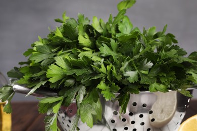 Colander with fresh parsley on table, closeup