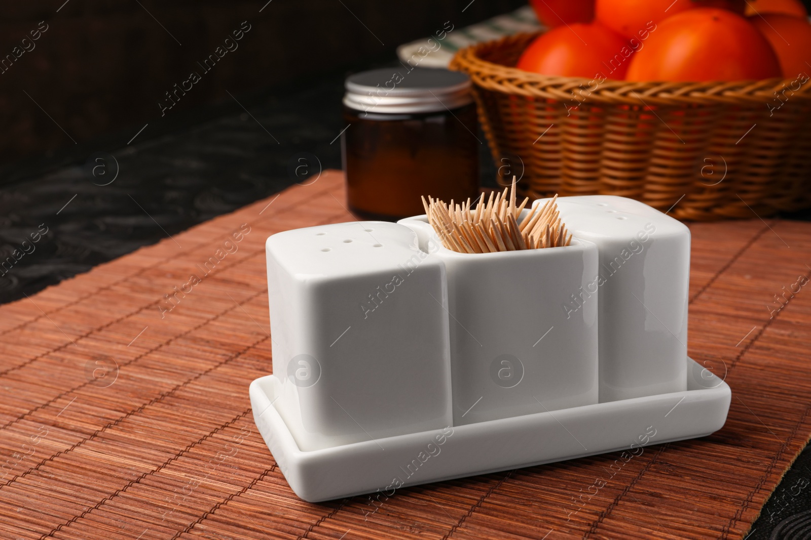 Photo of Holder with salt, pepper and toothpicks on bamboo mat