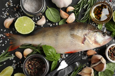 Fresh raw perch and ingredients on black slate table, flat lay. River fish