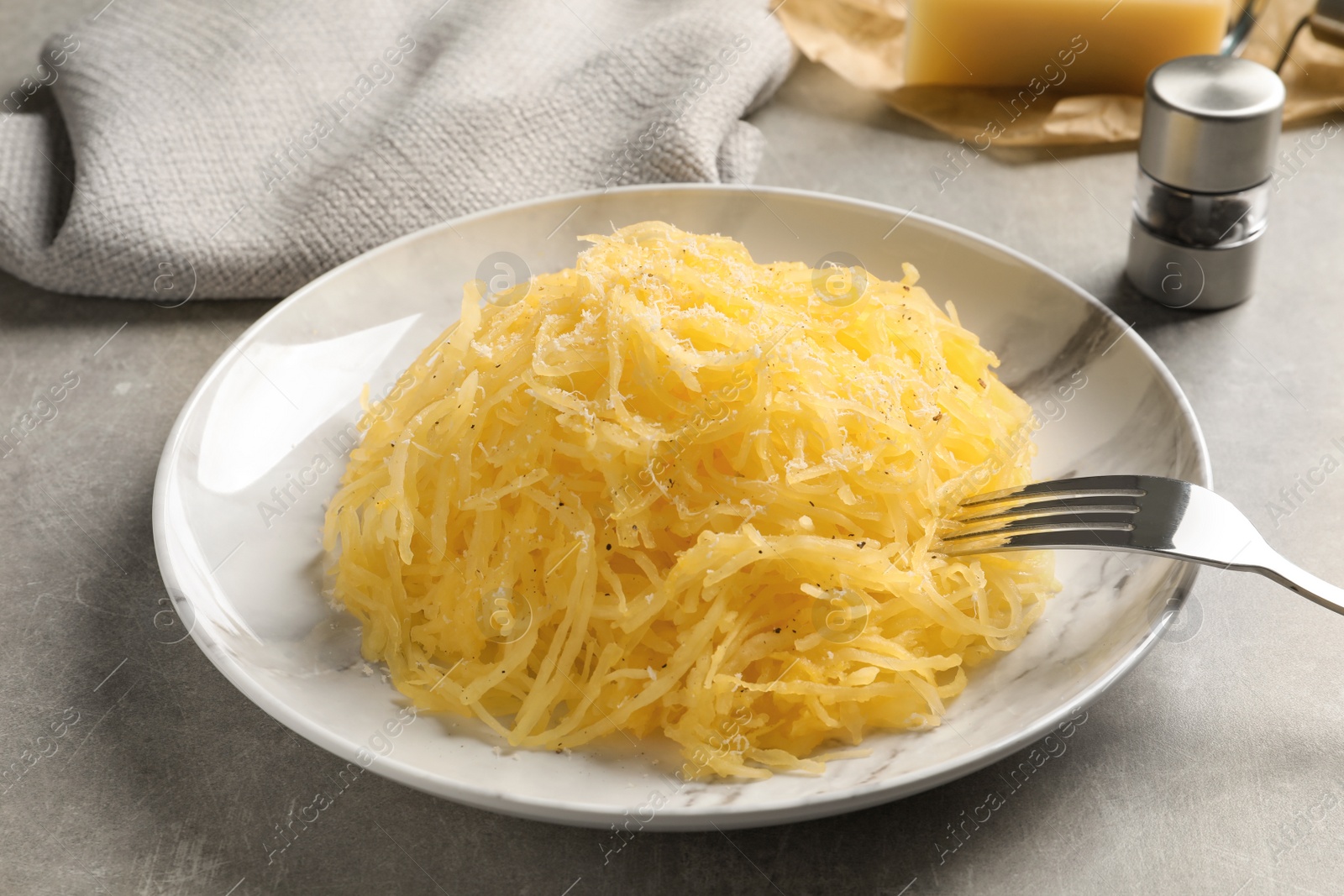 Photo of Plate with cooked spaghetti squash on gray table