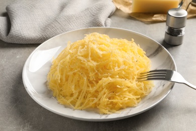 Photo of Plate with cooked spaghetti squash on gray table