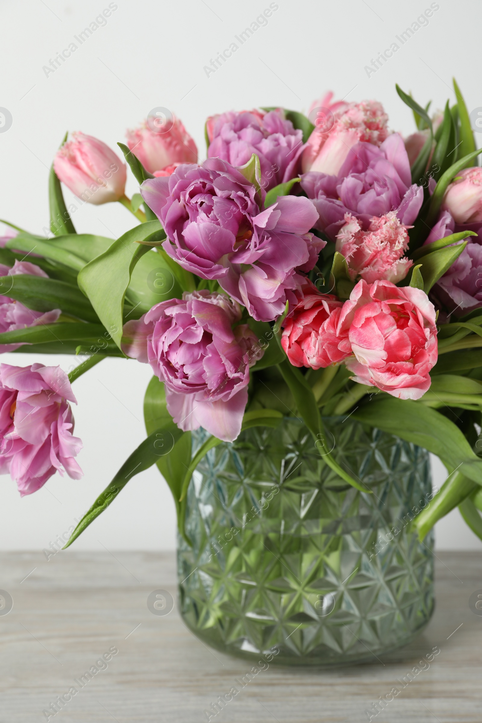 Photo of Beautiful bouquet of colorful tulip flowers on wooden table