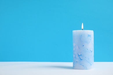 Photo of Alight wax candle on color background. Space for text