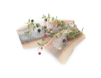 Photo of Delicious salted herring with thyme and peppercorns on white background, top view