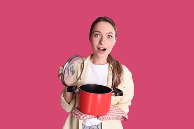 Photo of Surprised woman with pot on crimson background