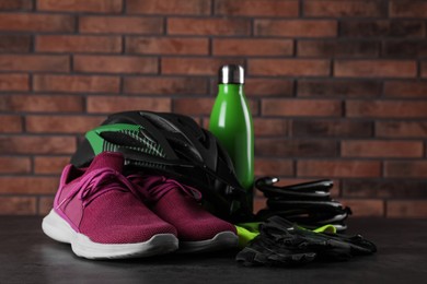 Photo of Different cycling accessories on black table against brick wall