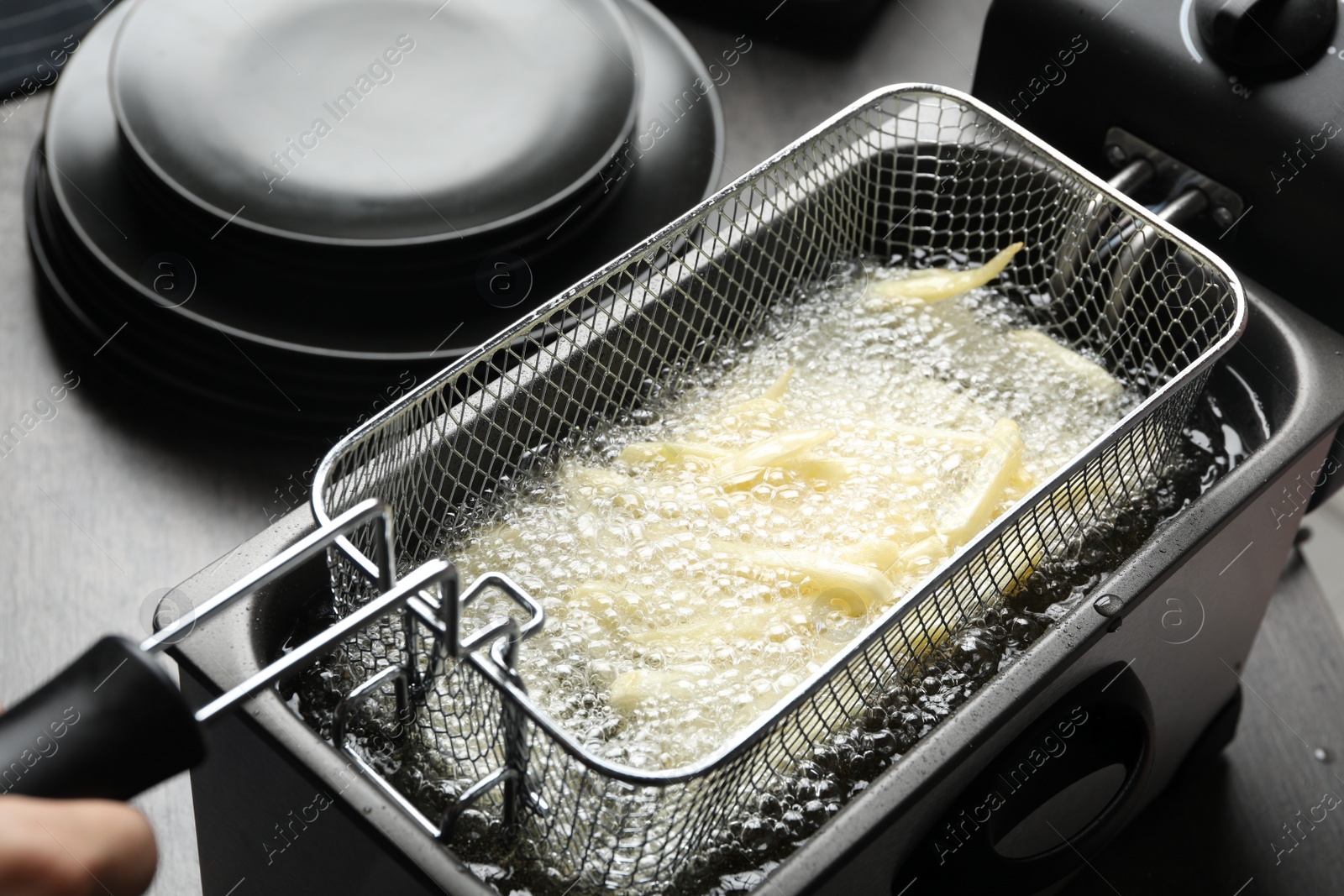 Photo of Cooking delicious french fries in hot oil