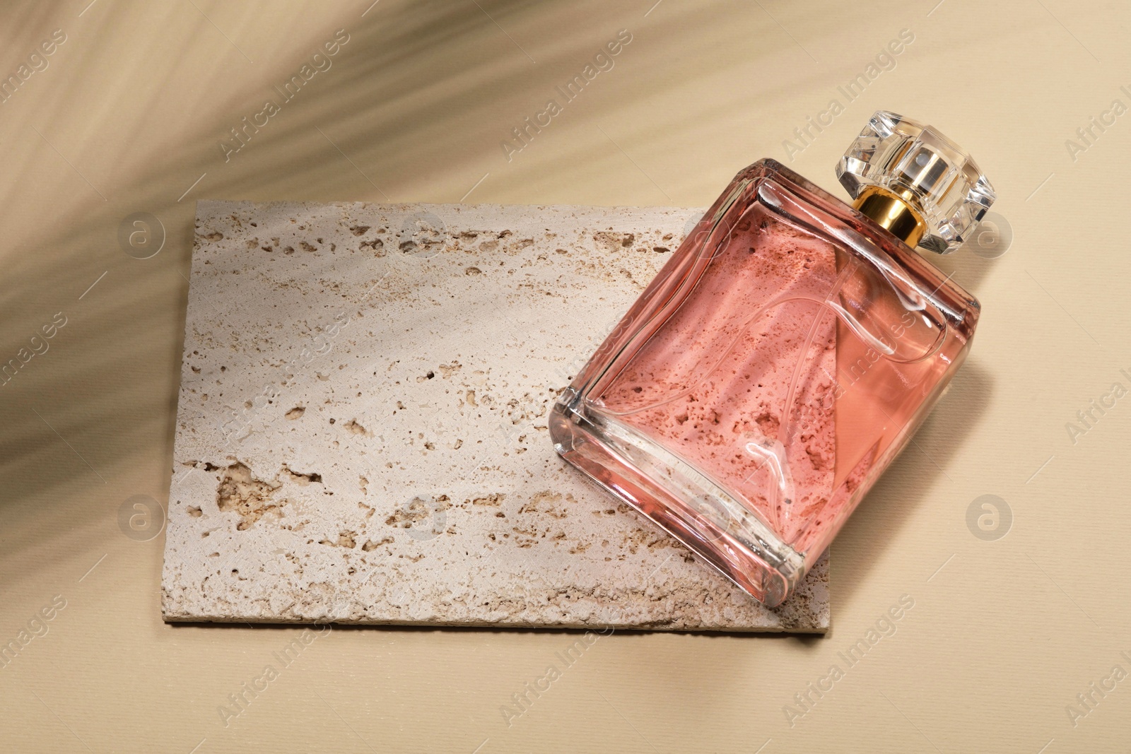 Photo of Luxury women's perfume in bottle on beige background, above view