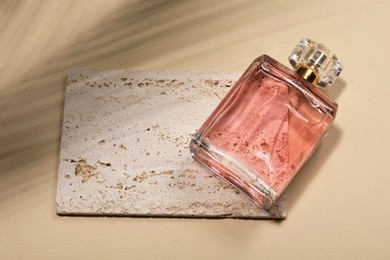 Photo of Luxury women's perfume in bottle on beige background, above view