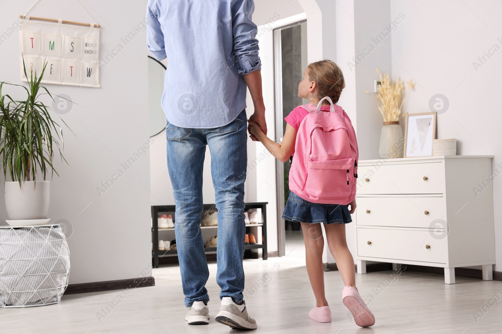 Photo of Little girl with father at home. Ready to go to school