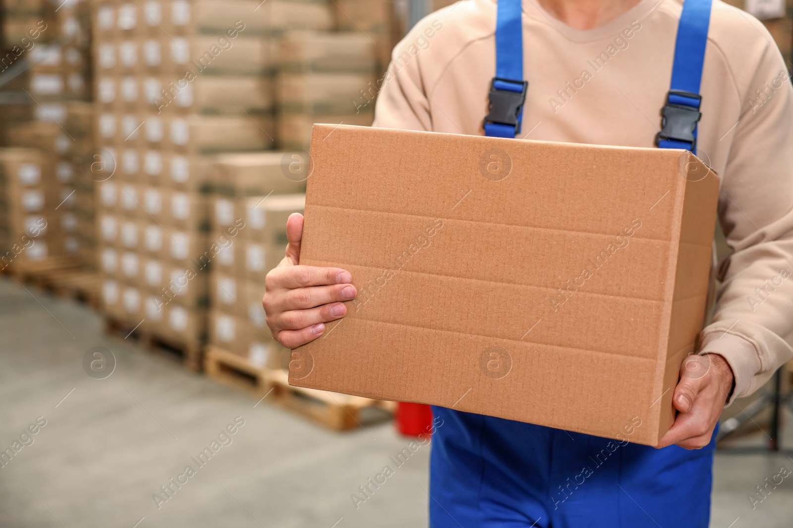 Photo of Worker with cardboard box in warehouse, closeup. Wholesaling