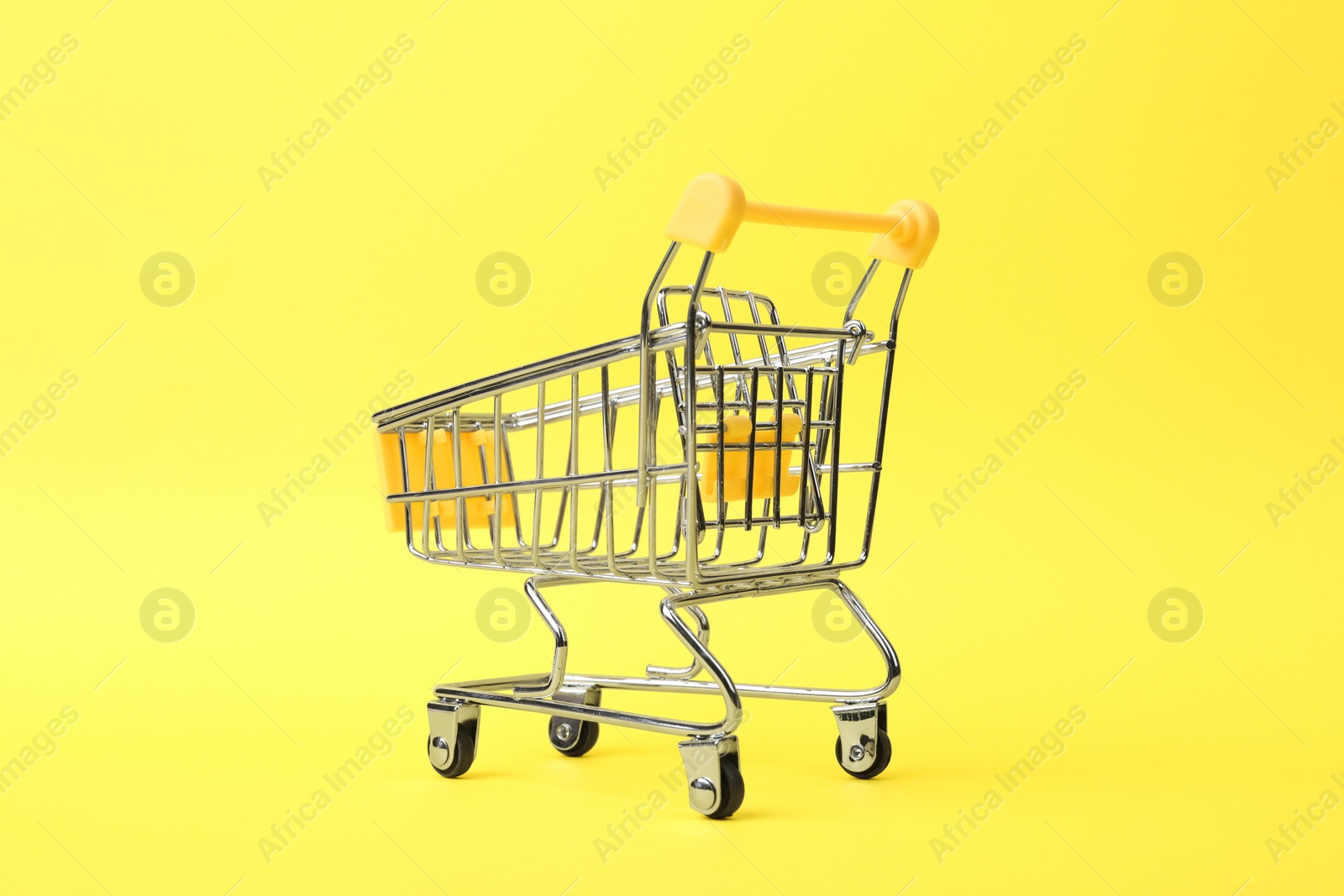 Photo of Empty shopping trolley with handle on color background