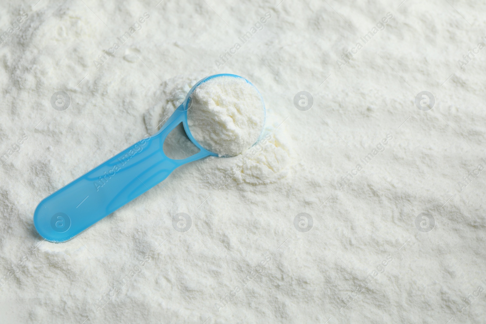 Photo of Top view of powdered infant formula and scoop, space for text. Baby milk