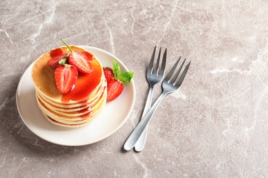 Photo of Plate with pancakes and berries on grey background