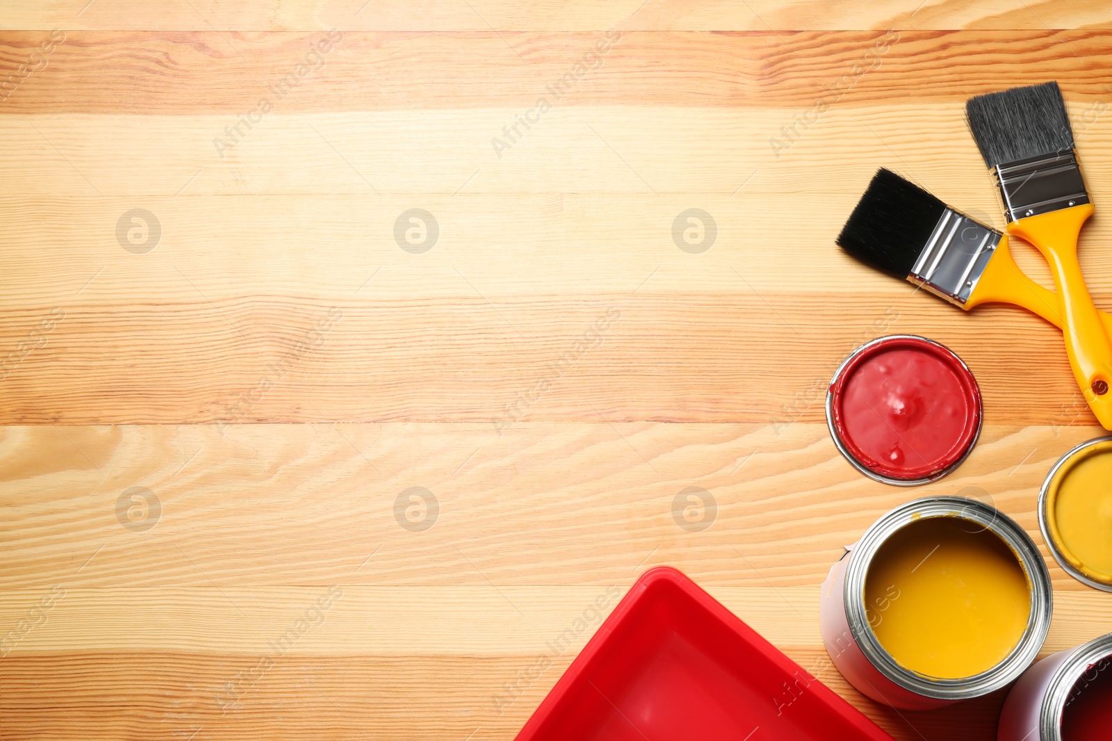 Photo of Flat lay composition with paint cans and brushes on wooden background. Space for text
