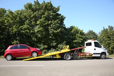 Photo of Broken car and tow truck on country road