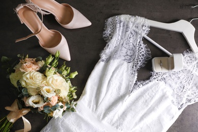 Flat lay composition with white wedding dress on grey stone table