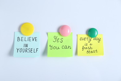Photo of Notes with motivational quotes on white background, flat lay