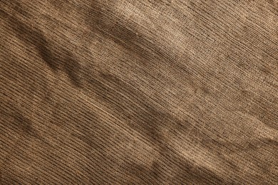 Photo of Texture of natural burlap fabric as background, top view