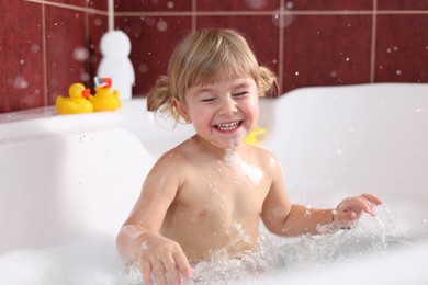 Photo of Happy girl having fun in bathtub at home