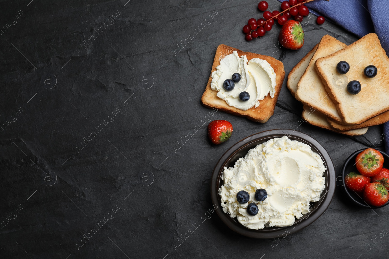 Photo of Tasty cream cheese, fresh berries and bread slices on black table, flat lay. Space for text