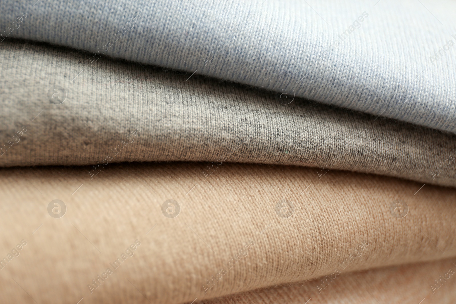 Photo of Stack of cashmere clothes as background, closeup