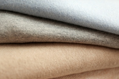 Photo of Stack of cashmere clothes as background, closeup