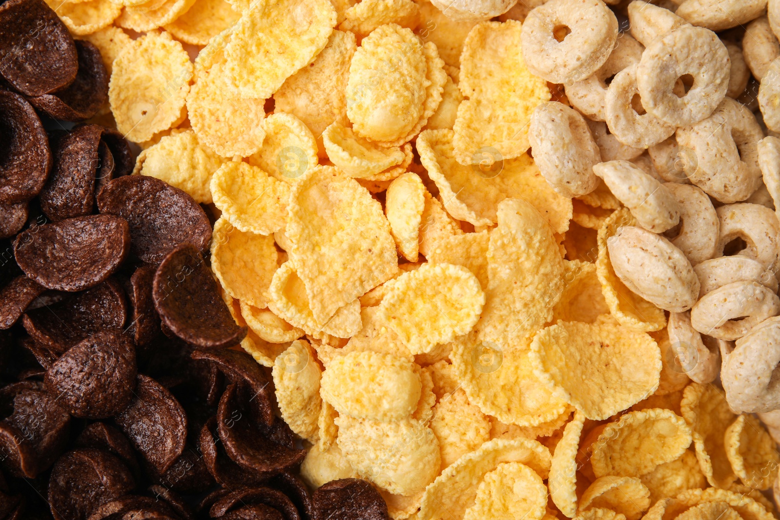 Photo of Different types of breakfast cereals as background, top view