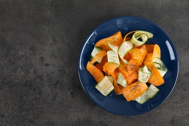 Plate with tasty carrot salad on table, top view