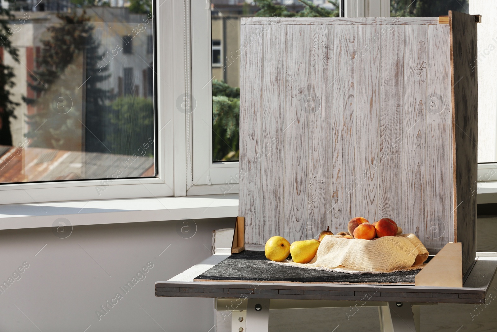 Photo of Juicy fruits and double-sided backdrops on table in photo studio. Space for text