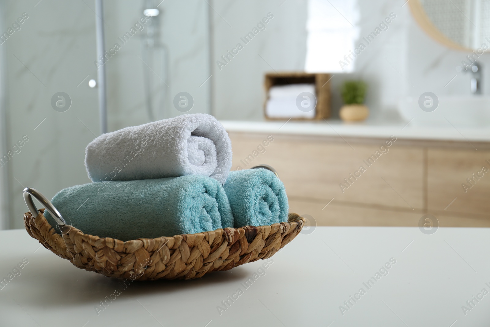 Photo of Wicker tray with clean soft towels in bathroom. Space for text