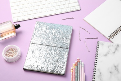 Blogger's workplace with notebook and keyboard on color background