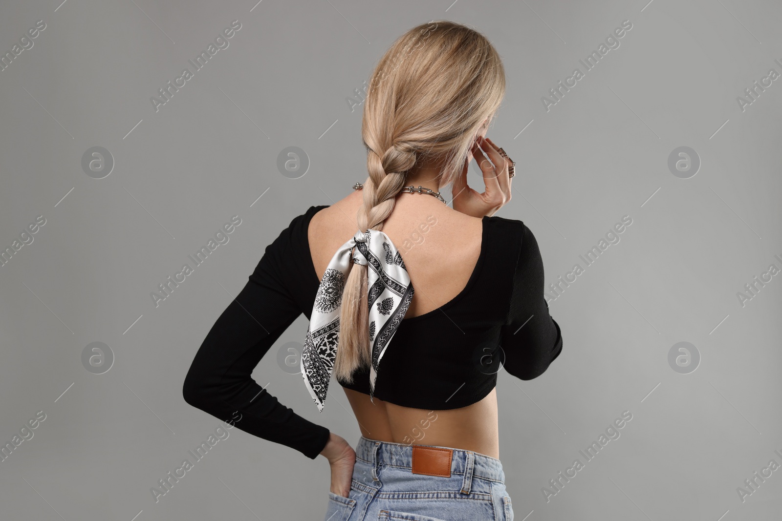 Photo of Woman with stylish bandana on light grey background, back view