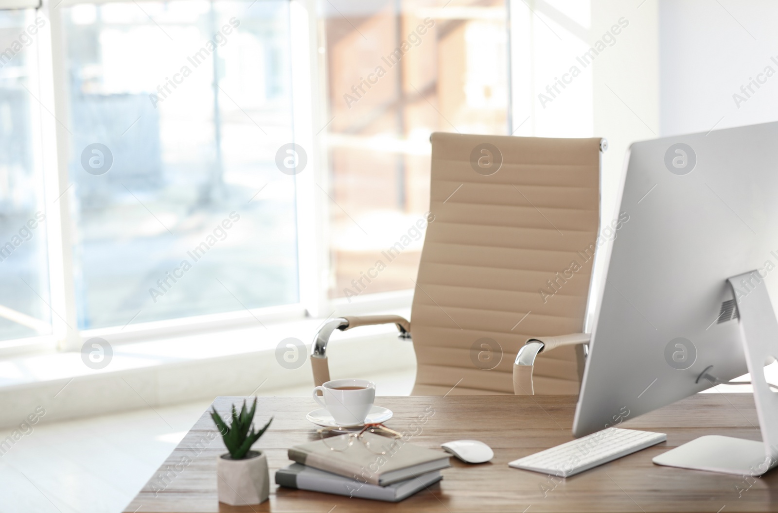 Photo of Computer, notebooks and coffee on table in office