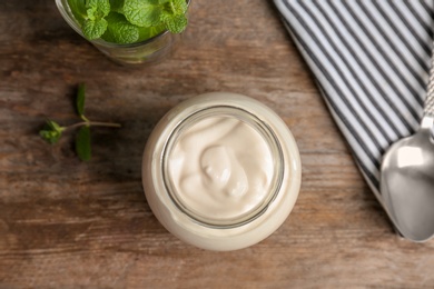 Jar with yummy yogurt on wooden table