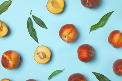 Flat lay composition with sweet juicy peaches on light blue background