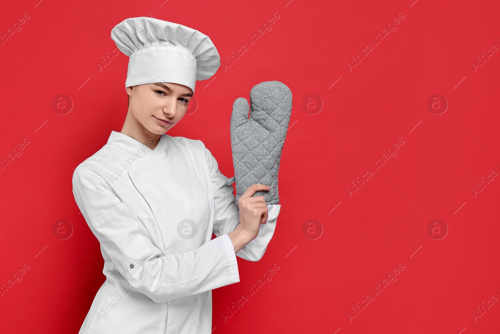 Photo of Professional chef with oven glove on red background. Space for text