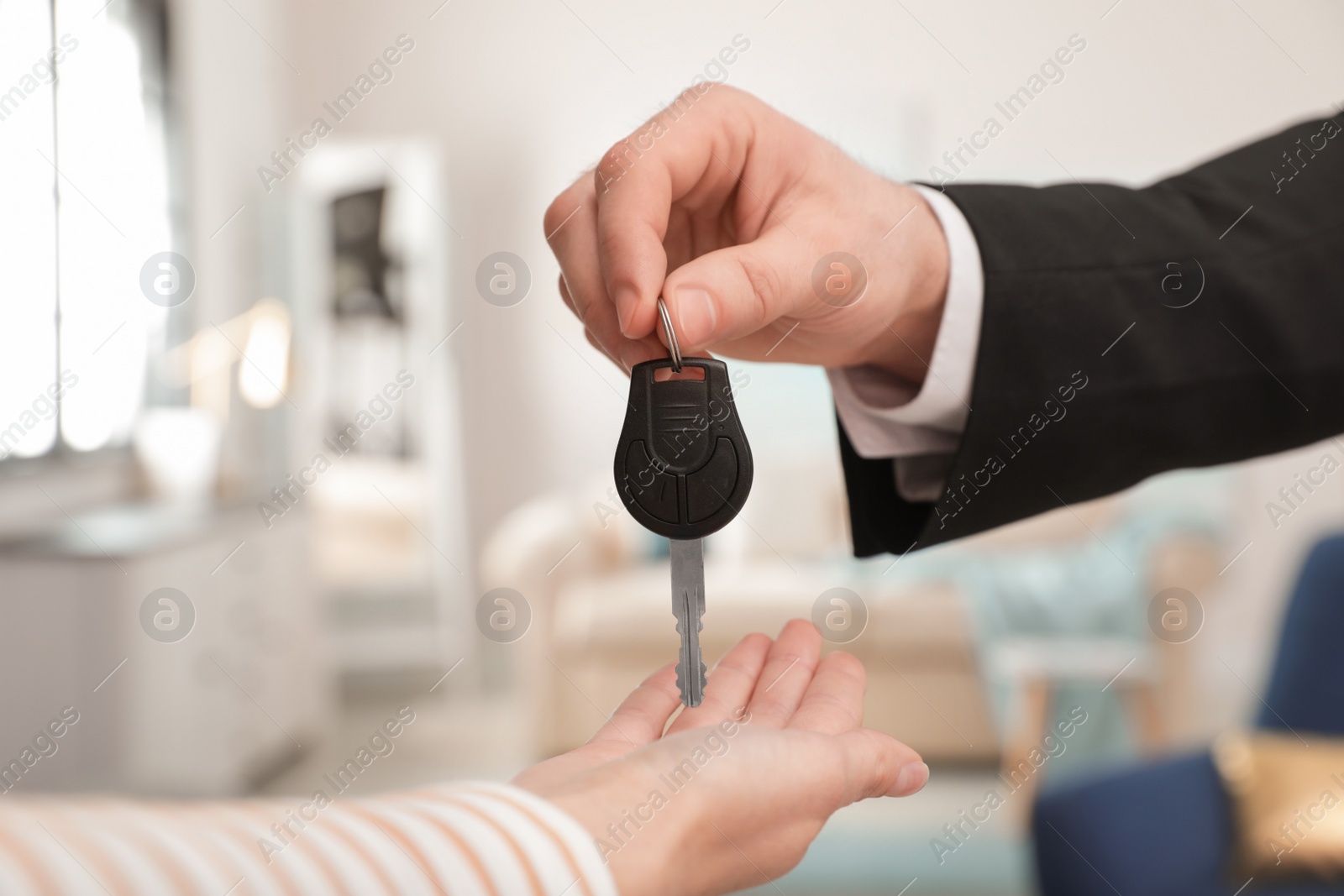 Photo of Man giving car key to woman indoors, closeup. Space for text