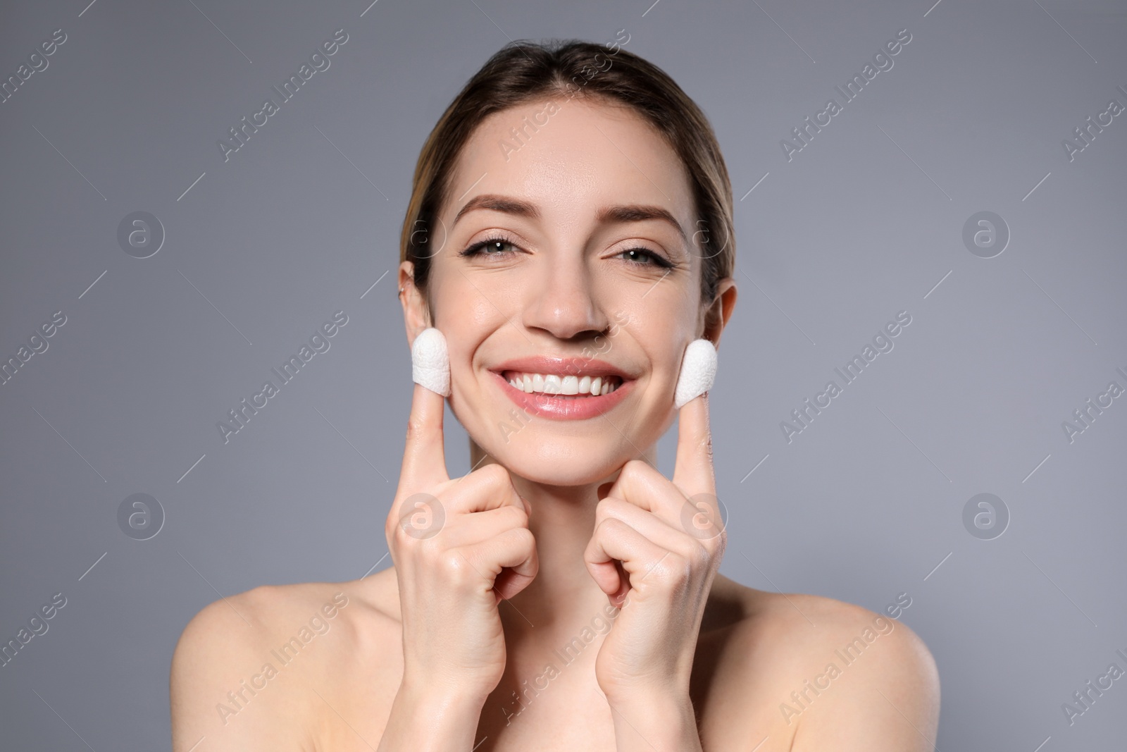 Photo of Woman using silkworm cocoons in skin care routine on grey background