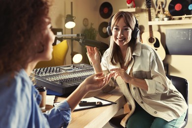 Photo of Radio host interviewing young African American woman in modern studio