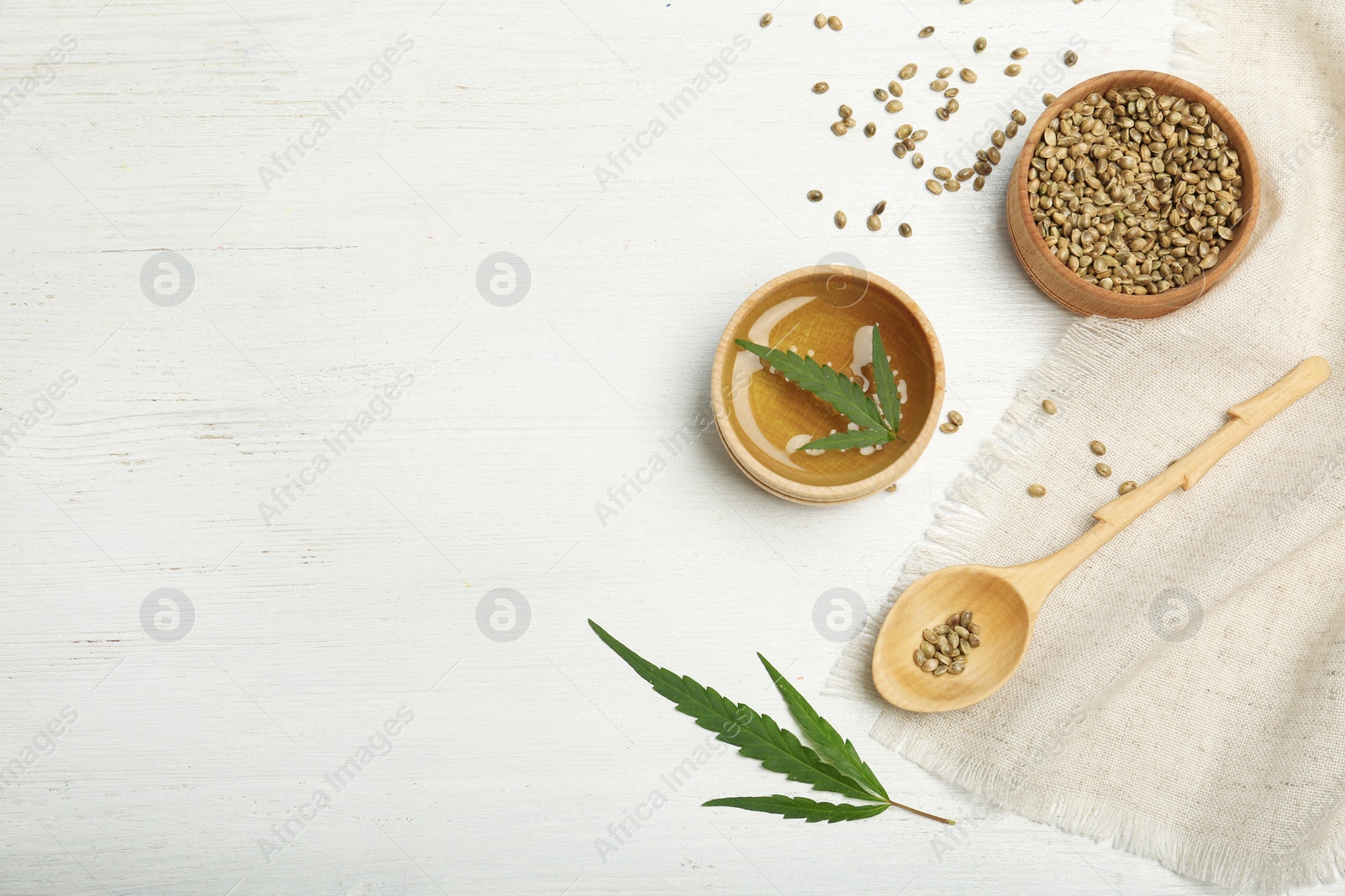 Photo of Hemp oil, seeds and space for text on white wooden background, flat lay